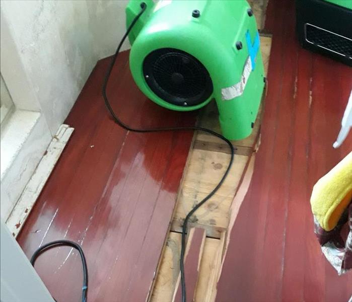 air mover on floor boards drying out water after a flood